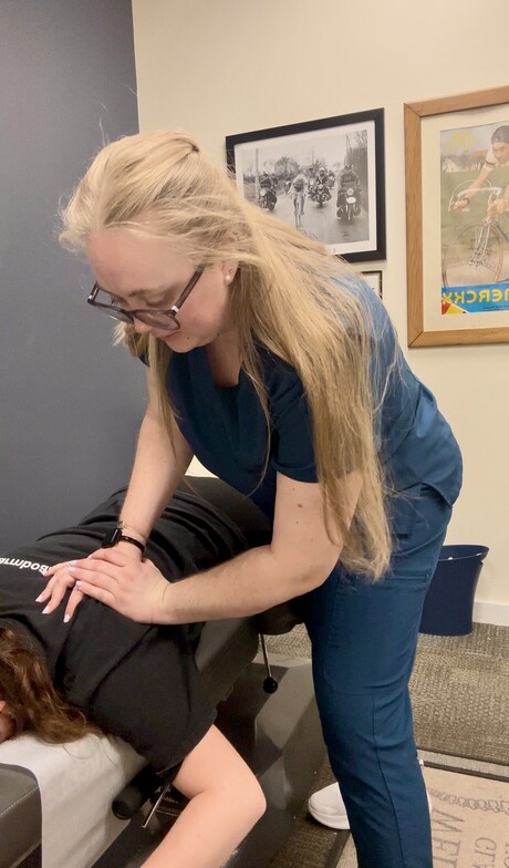 Chiropractor at Anchor Chiro performing a thoracic spine adjustment on a patient lying face-down on the treatment table