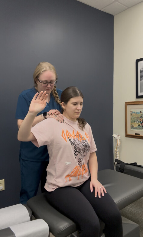 Chiropractor performing a shoulder and neck adjustment on a seated patient at Anchor Chiro in Somerville, NJ.
