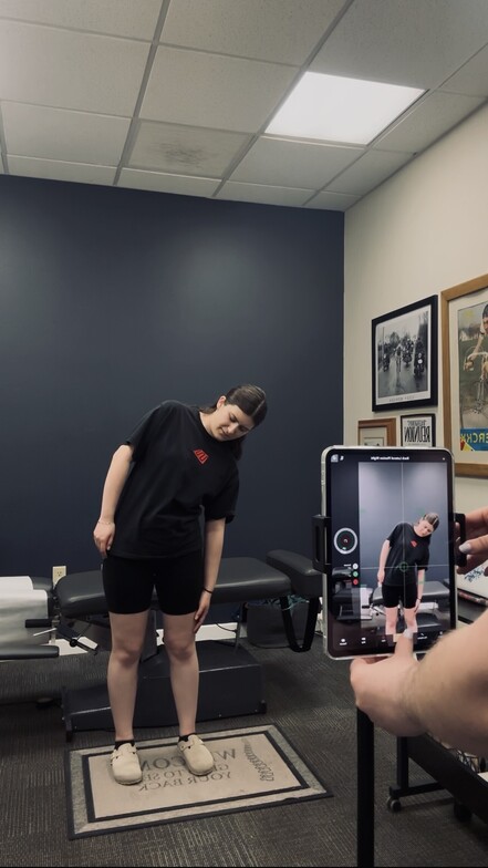 Patient performing a side bend during a Kinetisense movement assessment at Anchor Chiropractic